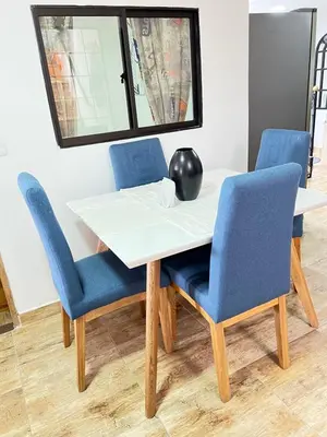 a table with two blue chairs and a vase on it at Acogedor apto en Sonsón in Sonsón