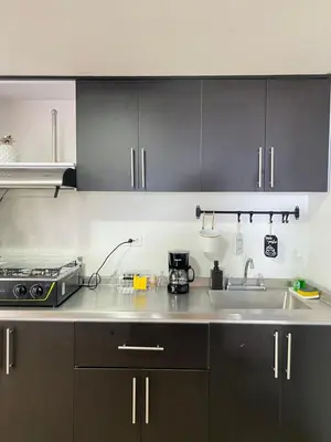 a kitchen with black cabinets and a sink at Acogedor apto en Sonsón in Sonsón