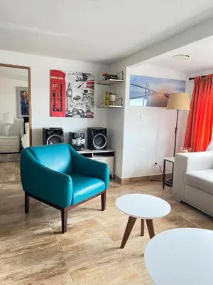a living room with a blue chair and a couch at Acogedor apto en Sonsón in Sonsón