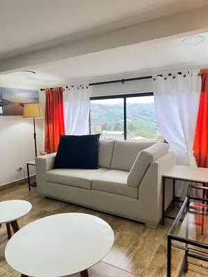 a living room with a couch and a large window at Acogedor apto en Sonsón in Sonsón