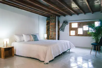 a bedroom with a bed and a brick wall at Hotel PIA Colombia in Marinilla