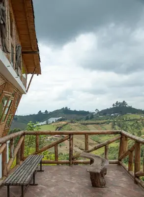 a wooden balcony with a bench and a view of a field at Hotel PIA Colombia in Marinilla