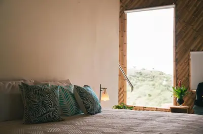 a bedroom with a bed with a large window at Hotel PIA Colombia in Marinilla