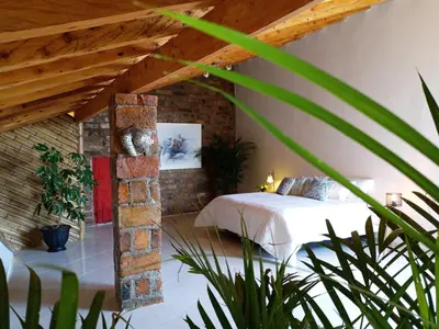 a bedroom with a bed and a brick wall at Hotel PIA Colombia in Marinilla