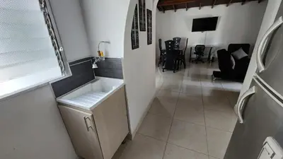 a kitchen with a sink and a living room at amplio apartamento en envigado in Envigado