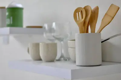 a kitchen counter with a white container with wooden utensils at Casa Flotante La Trinidad in Guatapé