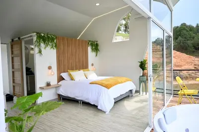 a bedroom with a bed and a balcony at Casa Flotante La Trinidad in Guatapé