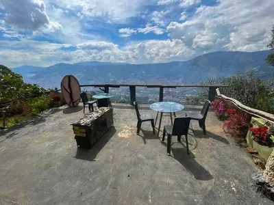 a table and chairs with a view of the mountains at Cabaña Parque Arvi vista panorámica in Medellín