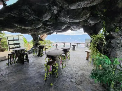 a group of tables and stools in a stone building at Cabaña Parque Arvi vista panorámica in Medellín