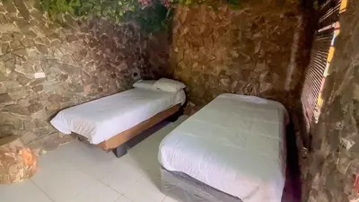 a room with two beds in a stone wall at Cabaña Parque Arvi vista panorámica in Medellín