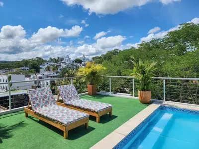 a balcony with two chairs and a swimming pool at MIRADORES DEL PARAISO in Doradal