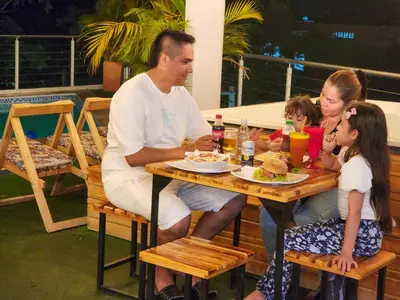 a family sitting at a table eating food at MIRADORES DEL PARAISO in Doradal