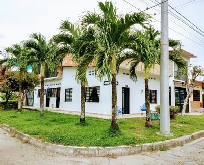 a group of palm trees in front of a building at Casa Vacacional in Mariquita