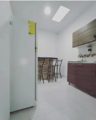 a kitchen with a refrigerator and some chairs in it at Casa Vacacional in Mariquita