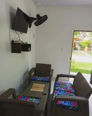 a room with two chairs and a tv on the wall at Casa Vacacional in Mariquita