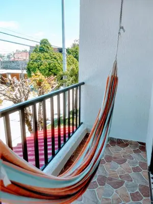 a hammock hanging on a balcony with a view at Casa Vacacional in Mariquita