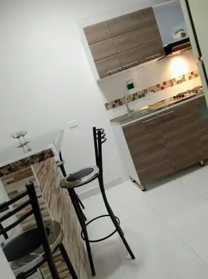 a kitchen with a black chair and a counter at Casa Vacacional in Mariquita
