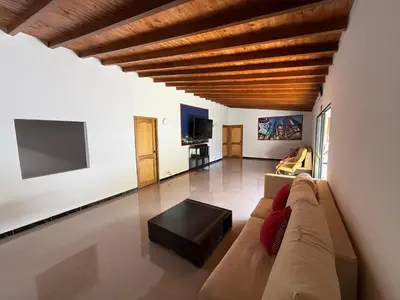 a living room with a couch and a tv at Hotel Selva Cristal in San Carlos