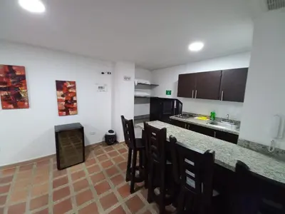 a kitchen with a counter and chairs in a room at Apartamento amoblado en la Francia in Manizales