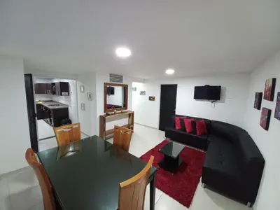 a living room with a table and a couch at Apartamento amoblado en la Francia in Manizales