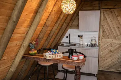 a kitchen with a table in a wooden cabin at Cabañas con jacuzzi y chimenea - Casa Floral, Marinilla in Marinilla