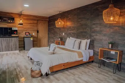 a bedroom with a large bed in a room at Cabañas con jacuzzi y chimenea - Casa Floral, Marinilla in Marinilla
