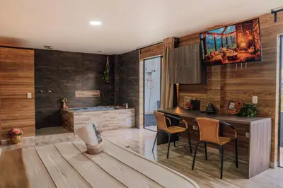 a kitchen with a table and chairs in a room at Cabañas con jacuzzi y chimenea - Casa Floral, Marinilla in Marinilla