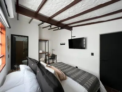 a bedroom with a bed and a flat screen tv at Casa Medallo in Medellín