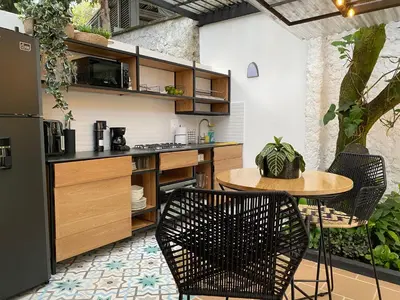 a kitchen with a table and two chairs and a counter at Casa Medallo in Medellín