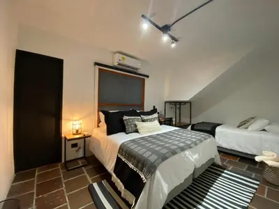 a bedroom with a bed and a nightstand and a bed sidx sidx sidx sidx at Casa Medallo in Medellín