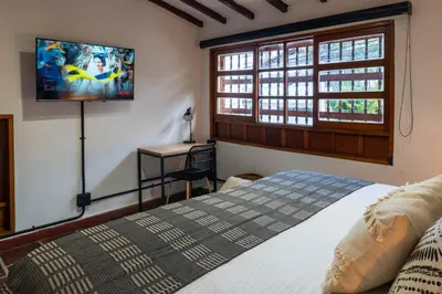 a bedroom with a bed and a television on the wall at Casa Medallo in Medellín