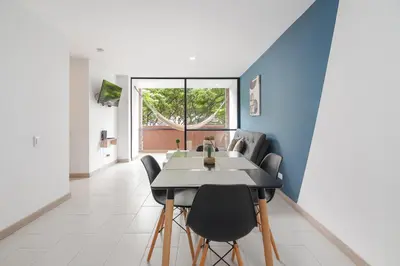 a dining room with blue walls and a table and chairs at Súper apartamento en Laureles in Medellín