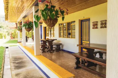a patio with benches and tables in a building at The Coffee Club Campestre in Chinchiná