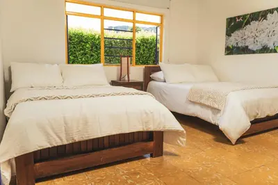 a bedroom with two beds and a window at The Coffee Club Campestre in Chinchiná