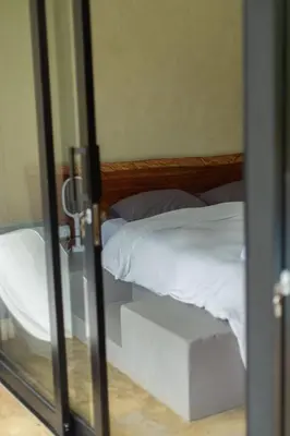 a glass door leading to a bed with white sheets at Cerro Tusa Springs in Venecia