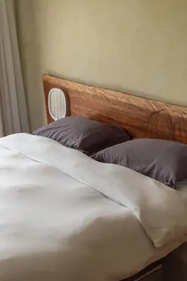 a white bed with a wooden headboard and two pillows at Cerro Tusa Springs in Venecia