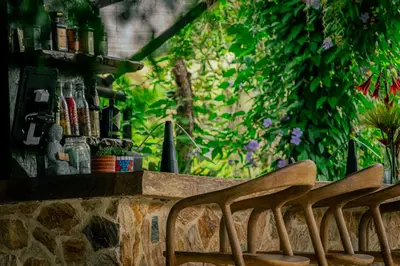 a row of wooden chairs sitting next to a wall at Cerro Tusa Springs in Venecia
