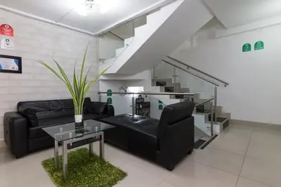 a living room with a black couch and a table at Ayenda 1254 Mi Colombia in Medellín
