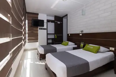 a hotel room with two beds and a television at Ayenda 1254 Mi Colombia in Medellín