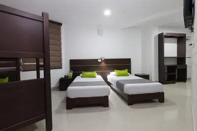 a bedroom with two beds with green pillows at Ayenda 1254 Mi Colombia in Medellín