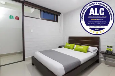 a bedroom with a bed with a sign on the wall at Ayenda 1254 Mi Colombia in Medellín