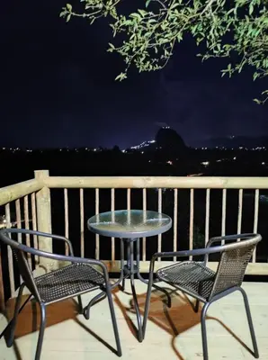 two chairs and a table on a deck with a table and chairs at Breeze Glamping -Guatape in El Peñol