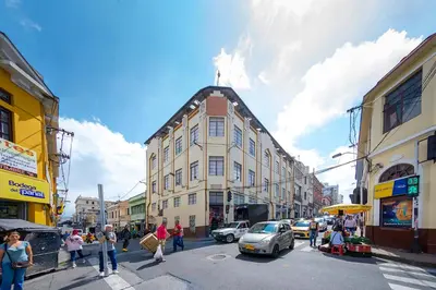 a group of people crossing a street in a city at Hotel Ayenda Macondo in Manizales