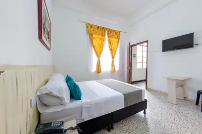 a bedroom with a bed and a window at Hotel Ayenda Macondo in Manizales
