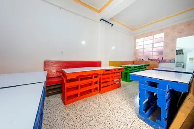 a kitchen with colorful tables and benches in a room at Hotel Ayenda Macondo in Manizales