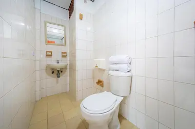 a white bathroom with a toilet and a sink at Hotel Ayenda Macondo in Manizales