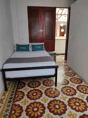 a bed in a room with a rug at Hotel Ayenda Macondo in Manizales
