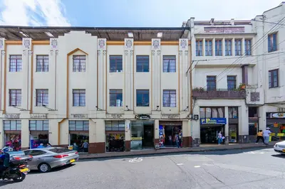 a large building on a street with cars parked in front at Hotel Ayenda Macondo in Manizales