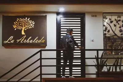 a man standing on the stairs of a building at Apartahotel La Arboleda HC in Manizales