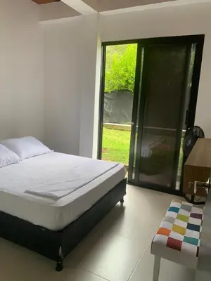 a bedroom with a bed and a sliding glass door at EL MILAGRO FINCA VACACIONAL in San Rafael